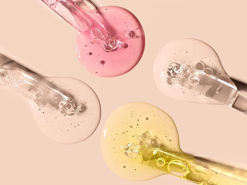 macro shot of four eyedroppers pouring epoxy on cream colored paper