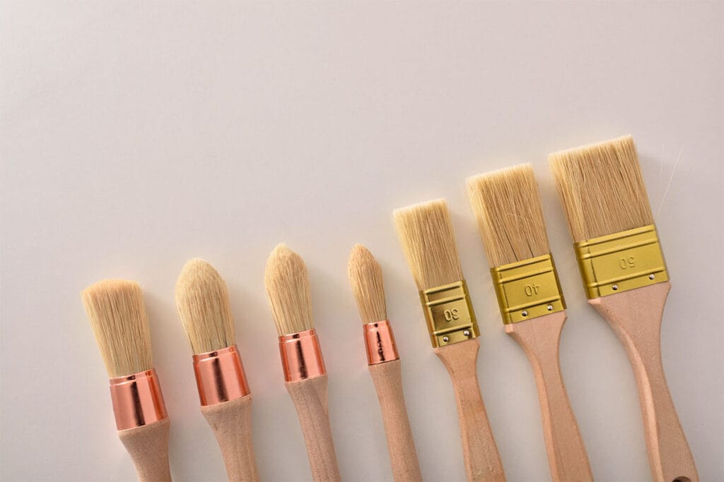 Close up of paint brushes bristles on a cream color paper