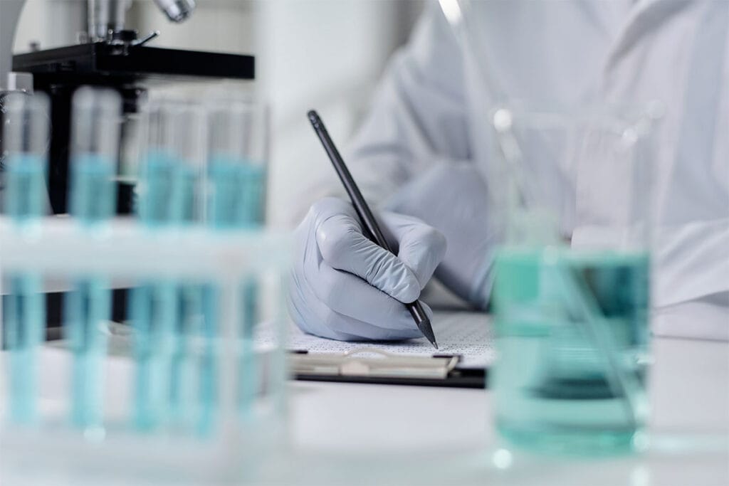 Scientist review check list with laboratory equipment in the foreground